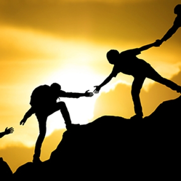 group helping each other up mountain